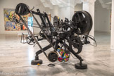 Jean TINGUELY
I925, Fribourg (Suisse) 1991 Berne (Suisse)
Rotozaza I
1967
Métal bois, moteurs, transformateurs et ballons
Inv. 2007.2.42
Transfert de collection de l’état,. attribution au (mac] musée d'art contemporain de Marseille en 2008. Œuvre restaurée en 2013 avec le concourt du ministère de la Culture, Paris.
La formation de Jean Tinguely se portage entre la fréquentation irrégulière des Beaux-Arts de Bâle et l'apprentissage de la décoration de magasins. À Paris; en 1953,9 réalise des reliefs animés dont le mécanisme est caractéristique des machines à dessiner qu’il produira plus tard. Il est le créateur d'un monde de bruit et de jeu de bricolage et d’ombrea Construites en partie à l’aide d’objets de récupération ses mécaniques; délibérément imparfaites; refusent le culte de l’objet neuf, produit d’une société de consommation En 1960, Tinguely intègre le groupe des Nouveaux Réalistes. À partir de 1963, il peint ses machines en noir, les privant ainsi de leur caractère d’objets trouvés.