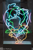 Martial RAYSSE
1936, Golfe-Juan (France). Éléments de vocabulaire pour dire peut-être quelque chose de simple et de doux
1968
Néons de couleur, caisson bois et plexiglas
lnv. C.68.223 Achat, 1968.
Éléments de vocabulaire pour dire peut-être quelque chose de simple et de doux apparaît à la fois comme un dessin au néon de trois couleurs différentes et comme une sculpture, bloc de couleurs immatérielle, sous plexiglas. Le titre nous offre un mode d'emploi : une déclaration pleine d'humour en forme de cœur, palmier, tète, et poules, comme une fable. L'artiste convoque des signes utilisés dans les rébus et nous invite à une formulation. Dans ce rébus suspendu aux teintes pastel, rien ne fait centre, les clichés Côte d'Azur, cœur, palmier et tête féminine sont bémolisés par le «  peut-être » du titre et par la présence des deux poules presque saugrenues. Les formes simples se fondent dans une douceur, sur laquelle l'artiste travaille.