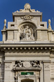 <center>L’école des beaux-arts</center>Deux anges sculptés couronnent la composition. Ils encadrent un cartouche gravé de l'année du début du projet de 1864. Au niveau supérieur, dans une niche, le sculpteur Félix Chabaud exécute « le Génie des Arts. »