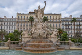 <center>Place de la Liberté</center>La fontaine de la Fédération. Le groupe sculpté se dresse au centre d'un grand bassin ovale agrémenté d'une série de bassins semi-circulaires formant cascades, et de chaque côté un mascaron déverse de l'eau dans une vasque en forme de coquille. Il est formé de trois figures principales à l'antique : la Liberté, ou la République triomphante, dressée sur un piédestal marqué des initiales RF ; elle est flanquée à gauche d'un personnage masculin symbolisant la Force ; et à droite d'un  personnage féminin représentant la Justice, avec lesquelles elle gouverne.
