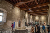 <center>Le Consistoire.</center>En 1413, un incendie détruit la charpente d'origine ainsi que l'ensemble des décors peints, exécutés dans les années 1346-1348, sous la direction de Matteo Giovannetti, peintre du pape Clément VI. Après une reconstruction puis un abandon progressif pendant l'occupation des Légats, le consistoire sert au stockage des armes et de poudre et le corps de bâtiment prend le nom d'aile des Suisses, gardes pontificaux.
Au départ de la caserne en 1906, l'aile du Consistoire, affecté aux logements des soldats, est en mauvais état. Après avoir été restaurée en détruisant les amé¬nagements militaires, ses planchers et son plafond sont reconstruits entre 1950 et 1980 en utilisant des tec
