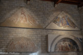 <center>Le Consistoire.</center>En 1340, Simone Martini, se voit confier la décoration du porche de la cathédrale Notre-Dame-des-Doms, par ce grand mécène qu’est le cardinal Jacopo Stefaneschi : Il réalise un cycle peint très ambitieux dont nous voyons ici les vestiges : deux tympans superposés, l’un circulaire, l’autre triangulaire, que sépare une corniche. A gauche, la sinopia
(nom italien ; au pluriel : sinopie). C’est le nom que l’on donne depuis le milieu du XXe siècle à cette esquisse faite avec un oxyde de fer ocre-rouge, que les peintres italiens faisaient venir de la région de Sinope (Turquie), sur la mer Noire.
La sinopia permet d’avoir une vision d’ensemble de l’œuvre ; le peintre a apporté quelques modifications et améliorations dans la composition et des portraits. En 1960, ces fresques sont si dégradées que le Service des Monuments Historiques décide de les déposer.
Les restaurateurs ont réussi un tour de force technique en décollant d’un seul tenant la sinopia du Christ Rédempteur de 5 mètres de long.