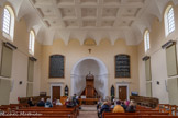 <center>Le temple de Lourmarin</center>Plafond à caissons plâtrés ornés d'une rosace ; tout autour, voussure creusée de pénétrations dont le nombre est double de celui des fenêtres qui éclairent la salle. <br> Peuplé, dans sa très grande majorité, de protestants, Lourmarin avait eu au 17e siècle un temple, dont l'emplacement précis, la date de construction et l'architecture ne sont pas connus. Il fut démoli par ordonnance royale en 1663. Contraints en 1685 d'abjurer leur foi, les lourmarinois lui demeurèrent néanmoins fidèles en dépit des persécutions et tracasseries diverses et eurent, comme ceux de Mérindol et de Cabrières-d'Aigues, une église du désert. La liberté de culte leur fut officiellement rendue en 1789, mais la période révolutionnaire ne leur permit guère d'en profiter (décret de 1793 supprimant les églises). Ce n'est que sous l'Empire que le consistoire de Lourmarin put former et mettre à exécution le projet d'édifier un temple. Il obtint le 30 mars 1805 l'autorisation d'acquérir à cet effet un terrain et confia à l'architecte Penchaud le soin de dresser les plans de l'édific
