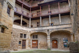 <center>Château de Lourmarin</center>La cour médiévale. Au rez-de-chaussée, deux grandes salles voûtées : la boulangerie et la cuisine où la nourriture et le vin étaient stockés. A gauche, la porte de la salle dite des réserves. Au-dessus de cette porte il y a l’inscription (1513) en gothique, « bois et t’en vas ». Elle marque la volonté de la famille d’Agoult de ne pas transformer le château en halte pour les voyageurs. Au-dessus, les galeries dites Loggia, initialement construites par les vaudois, qui avaient complètement disparu. Elles ont été restituées lors de la restauration grâce aux documents anciens fournis par Edouard Aude, ami de Robert Laurent-Vibert et conservateur de la bibliothèque Méjanes d'Aix.
