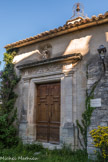 <center>Le Beaucet.</center> La porte est la seule partie extérieure de l'édifice décorée. Elle est encadrée de pilastres et surmontée d'une frise, d'une corniche et d'une statue de la Vierge à l'Enfant.