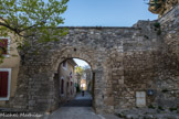 <center>Le Beaucet.</center> La porte sud, qui ouvre sur la place Castel Lou. Le village est traversé du nord au sud par une rue qui s’ouvre sur les deux portes d’accès. Du côté situé sur cette place, elle s’appelle rue « coste chaude », ce qui signifie littéralement le côté chaud du village et donc ensoleillé. Cette porte a été restaurée en 1650 comme l’indique l'inscription toujours visible. Du côté nord, elle se nomme rue « coste froide » car elle fait front au mistral.